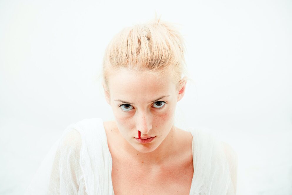 woman's bleeding nose with white background